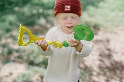 child with mini shovel in garden