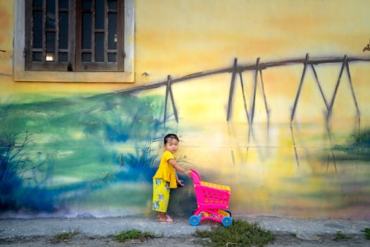 small child using a bright yellow watering can